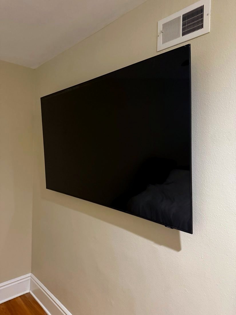 A large TV mounted close to a beige wall