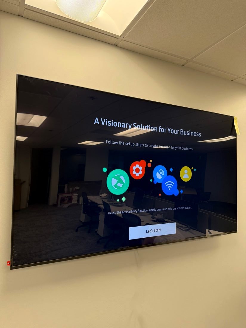 A large display mounted on a conference room wall