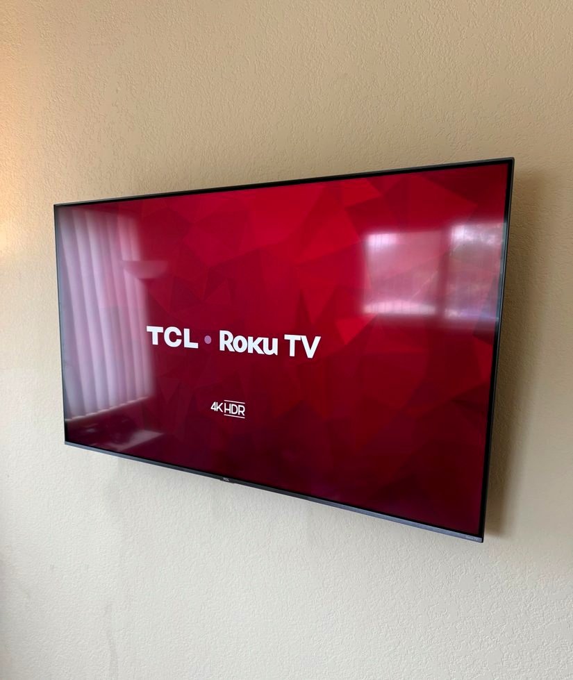 A TV mounted level on a living room wall showing its startup screen